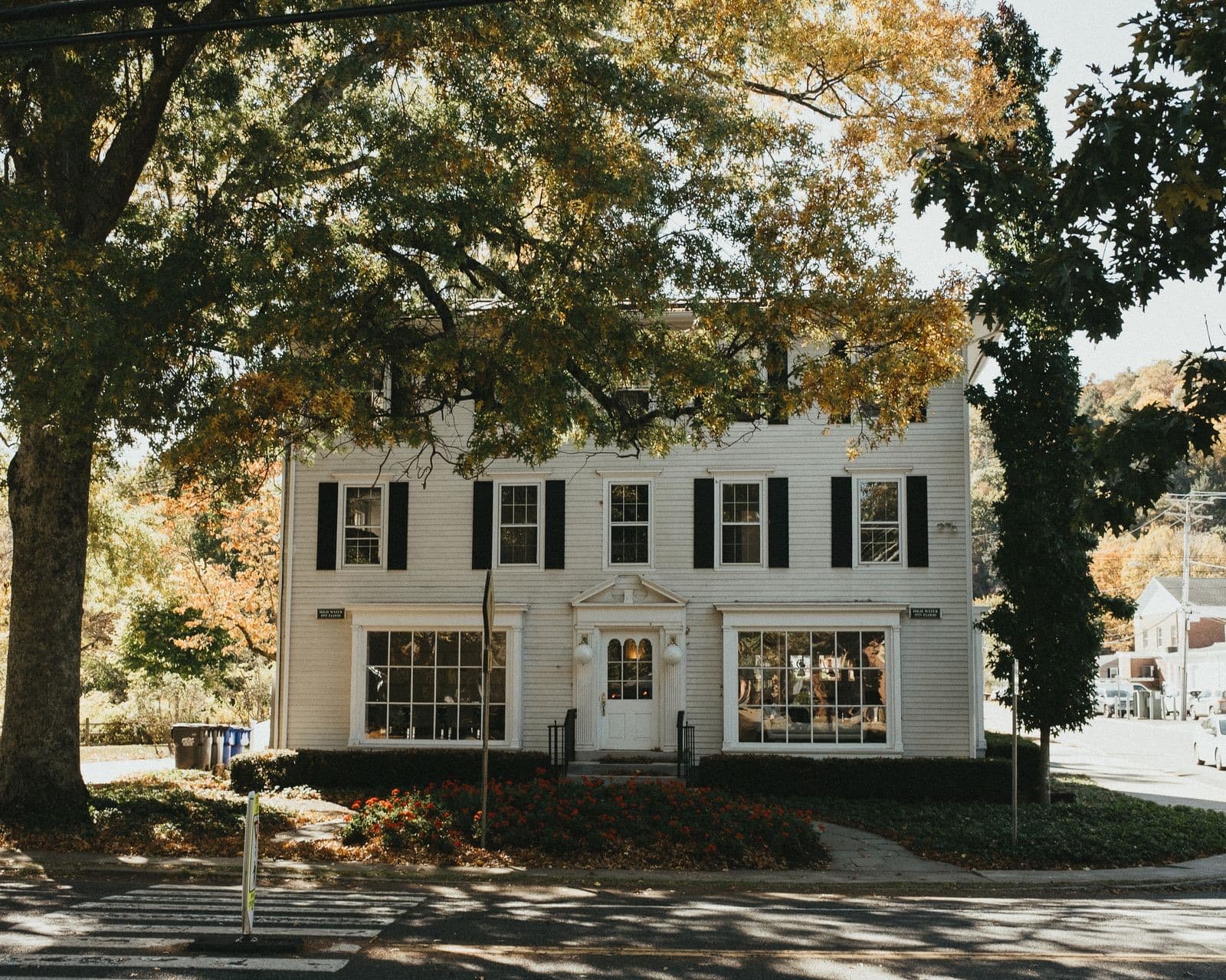 Beautiful colonial-style house surrounded by fall foliage