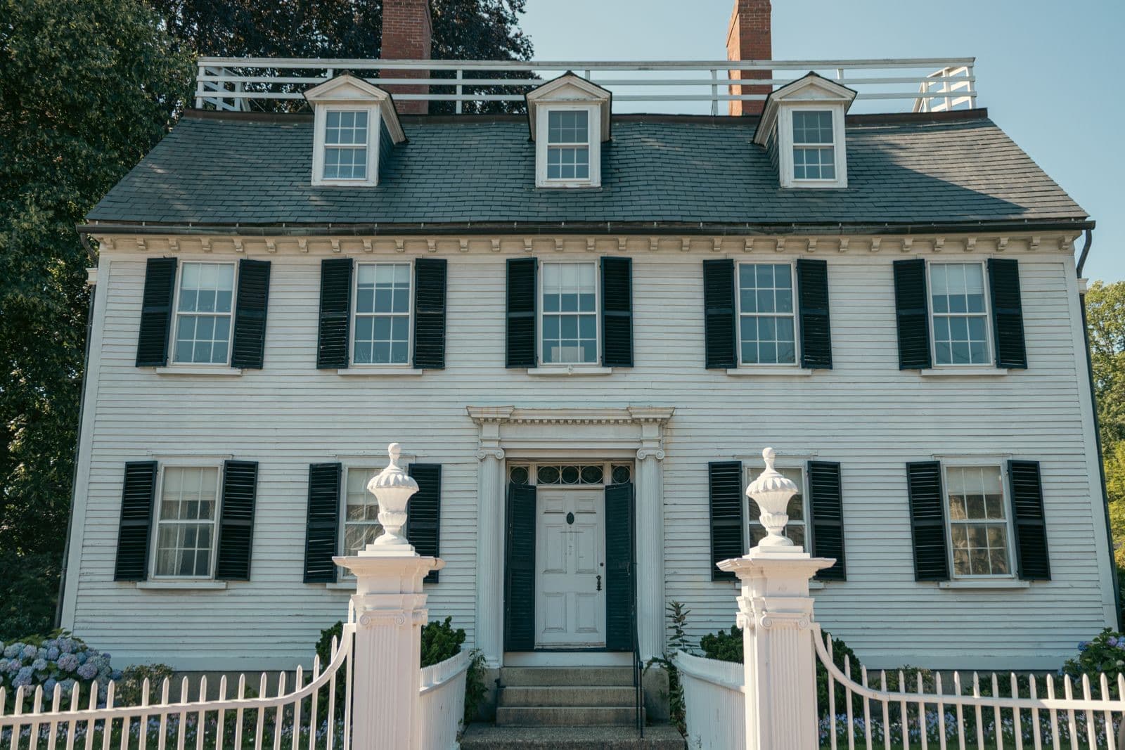 Elegant colonial-style house with a white picket fence