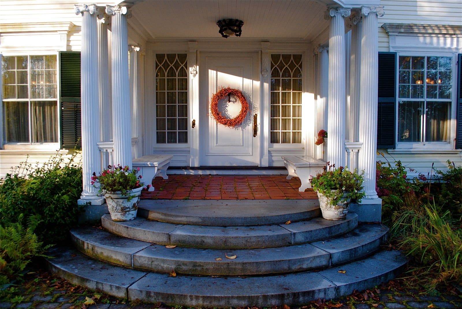 Charming entrance porch with an autumn wreath and stone steps