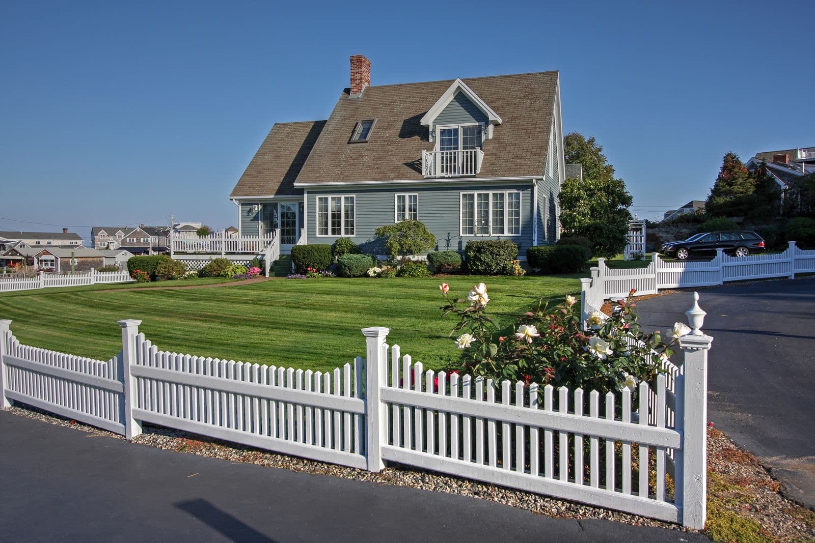 New England home with a white picket fence and manicured lawn