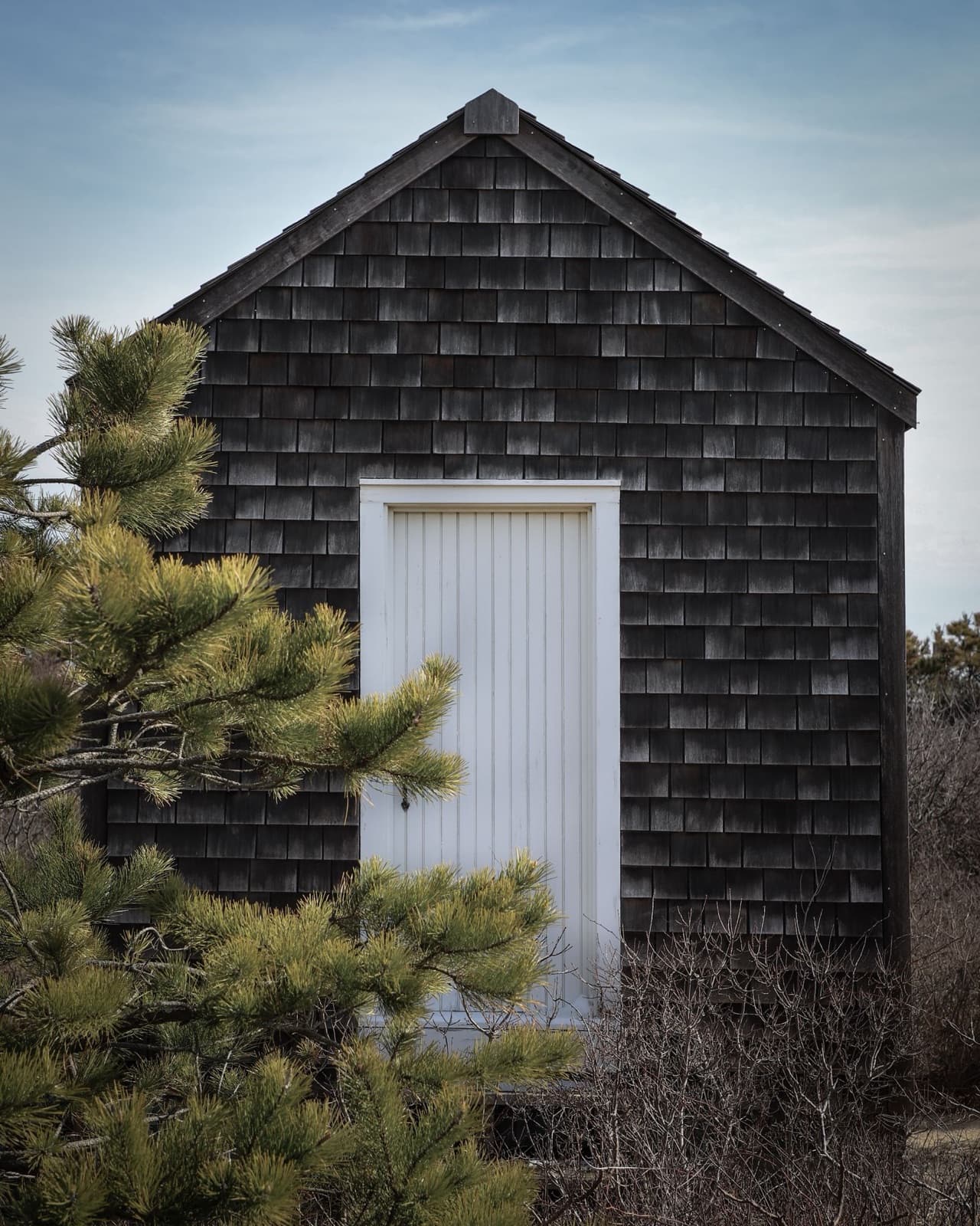 Rural barn with a classic white door and rustic shingles