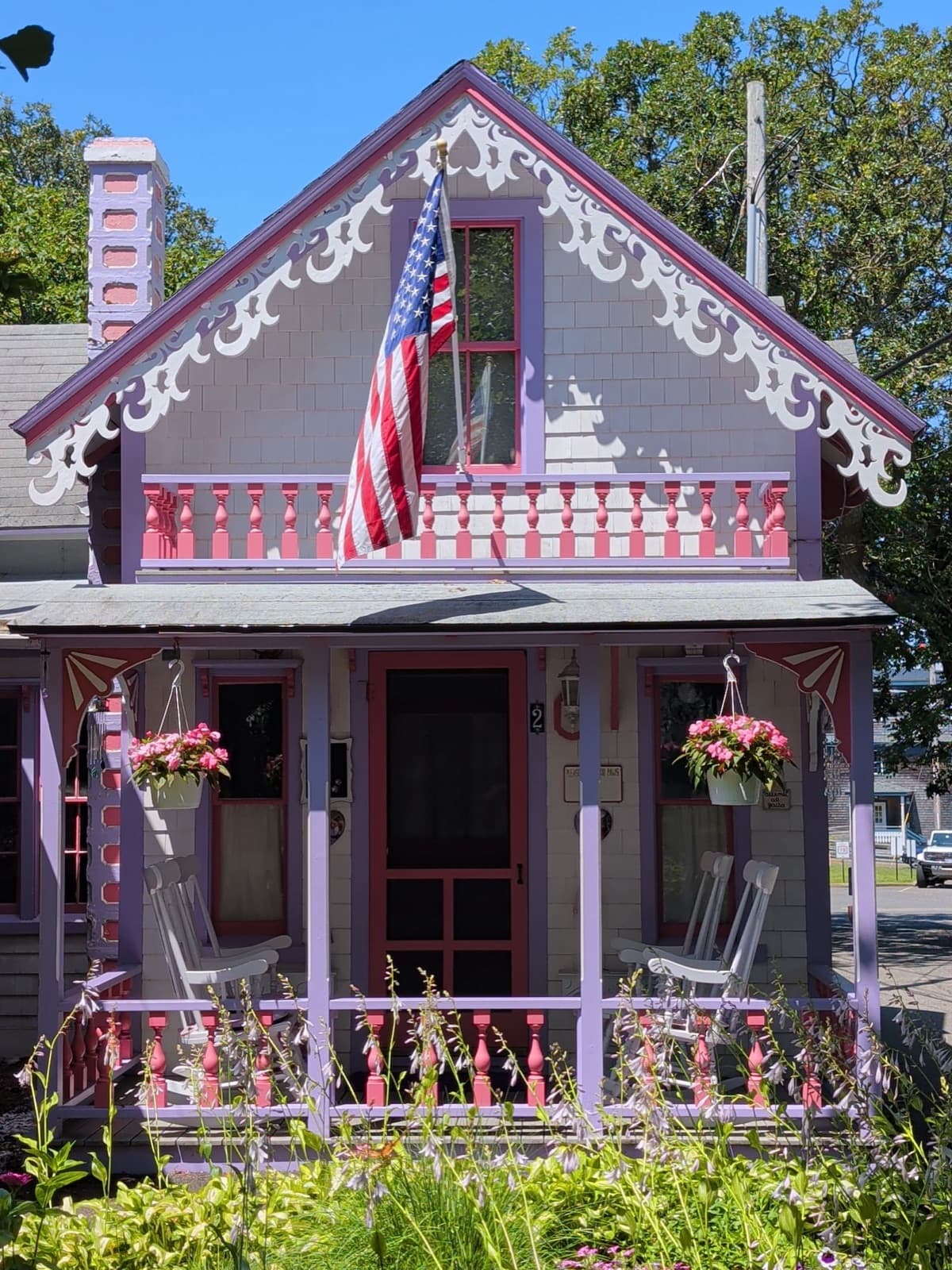 Colorful Victorian house with ornate trim and an American flag