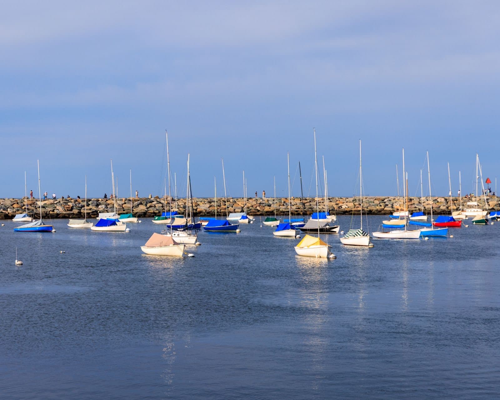 Colorful sailboats anchored in a harbor under a clear blue sky