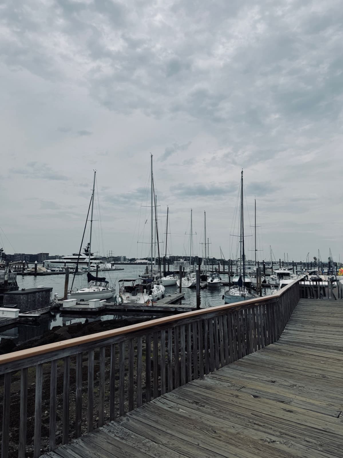 Peaceful harbor with anchored boats and a wooden boardwalk