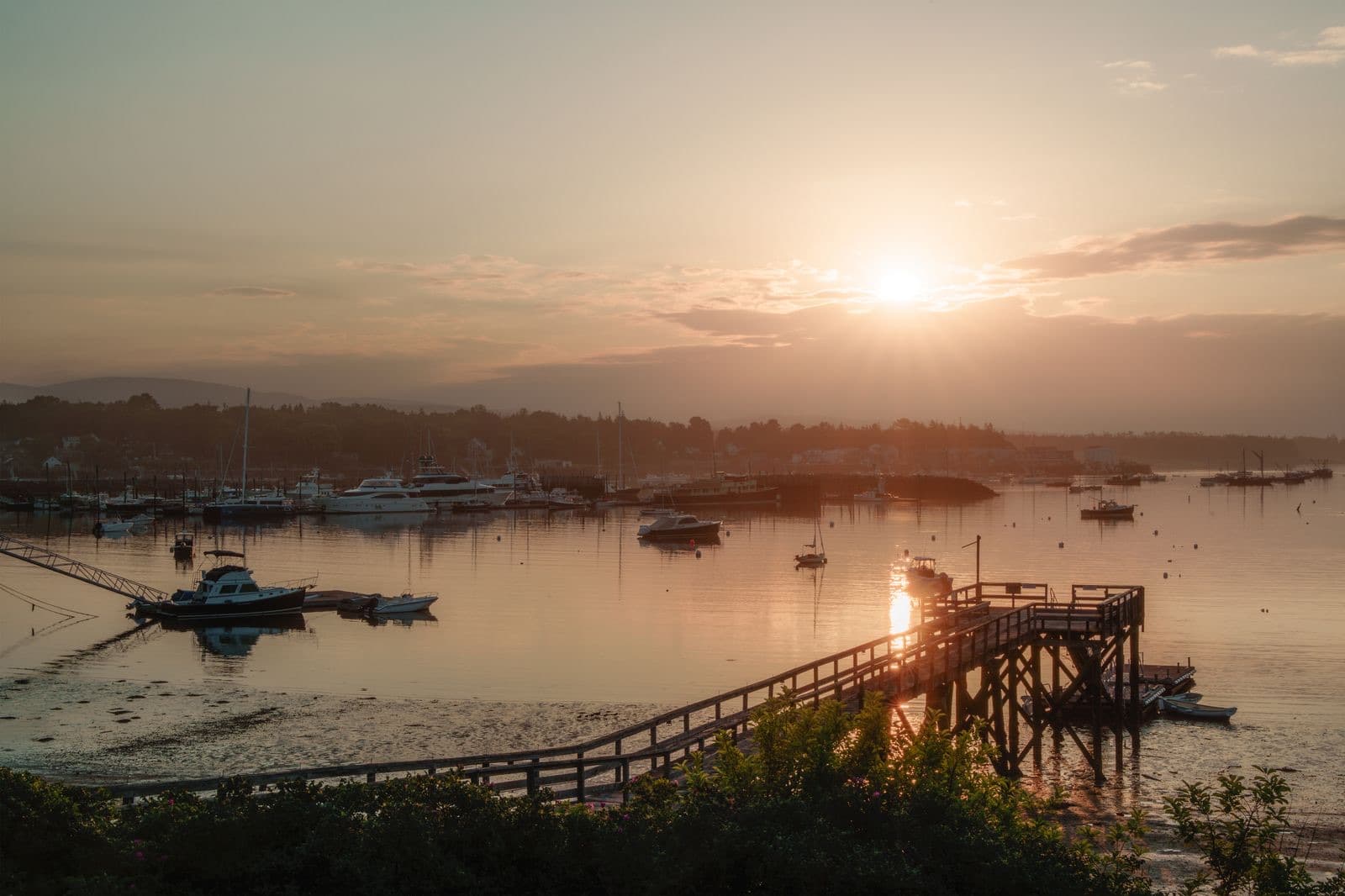 Serene sunrise over a marina with calm waters and boats