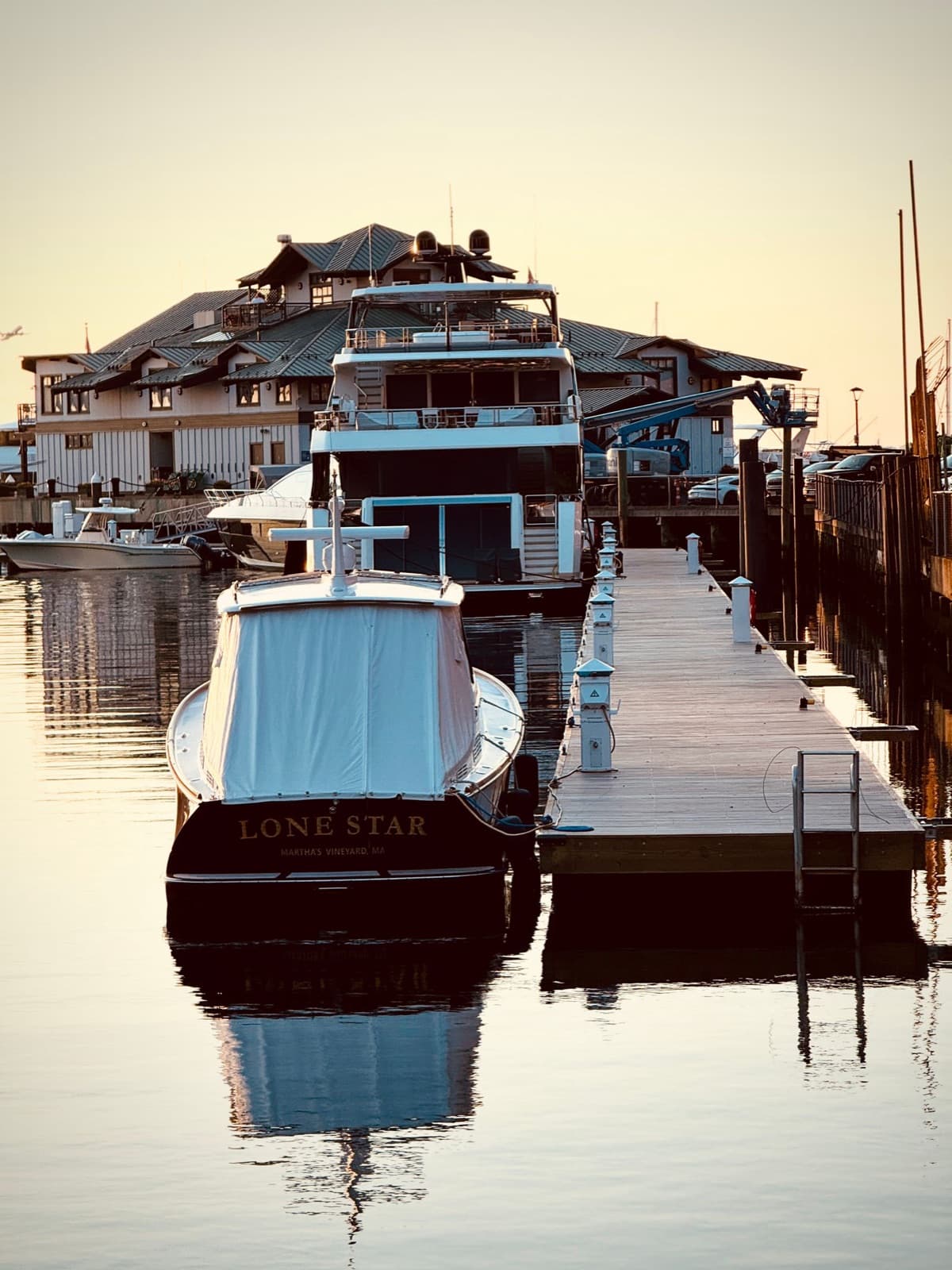 Yachts docked at a marina at sunset