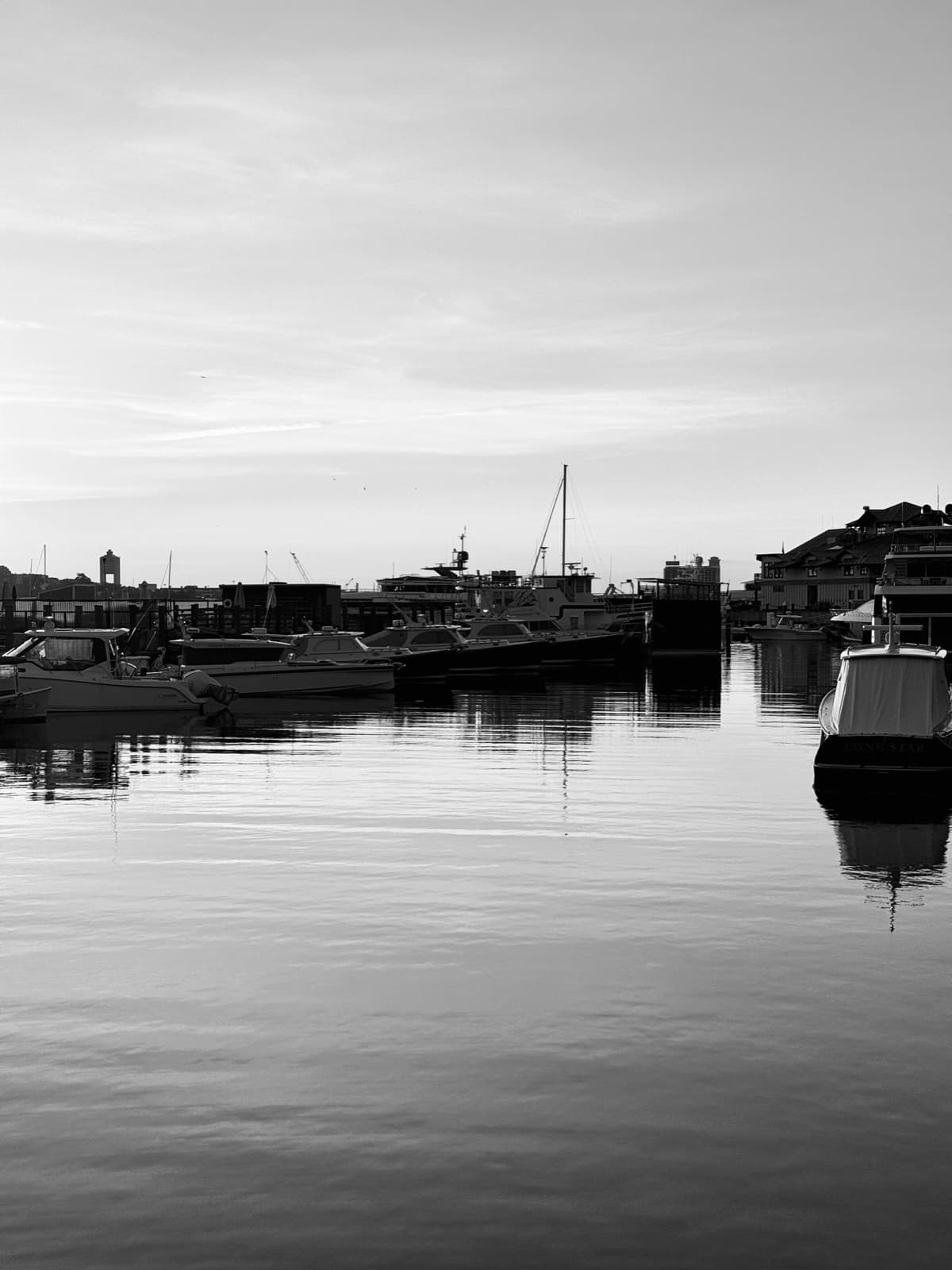 Serene morning view of a harbor with boats and reflections