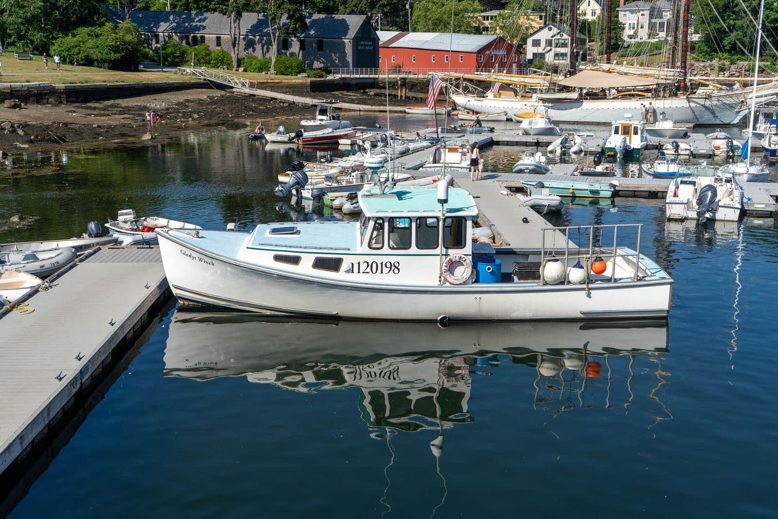 Fishing boat docked at a marina with coastal buildings