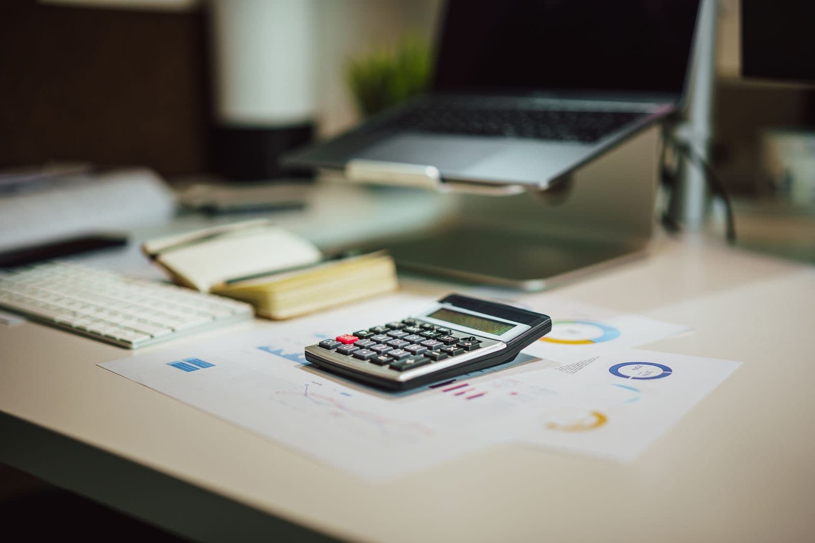 Workspace with a laptop, calculator, and documents