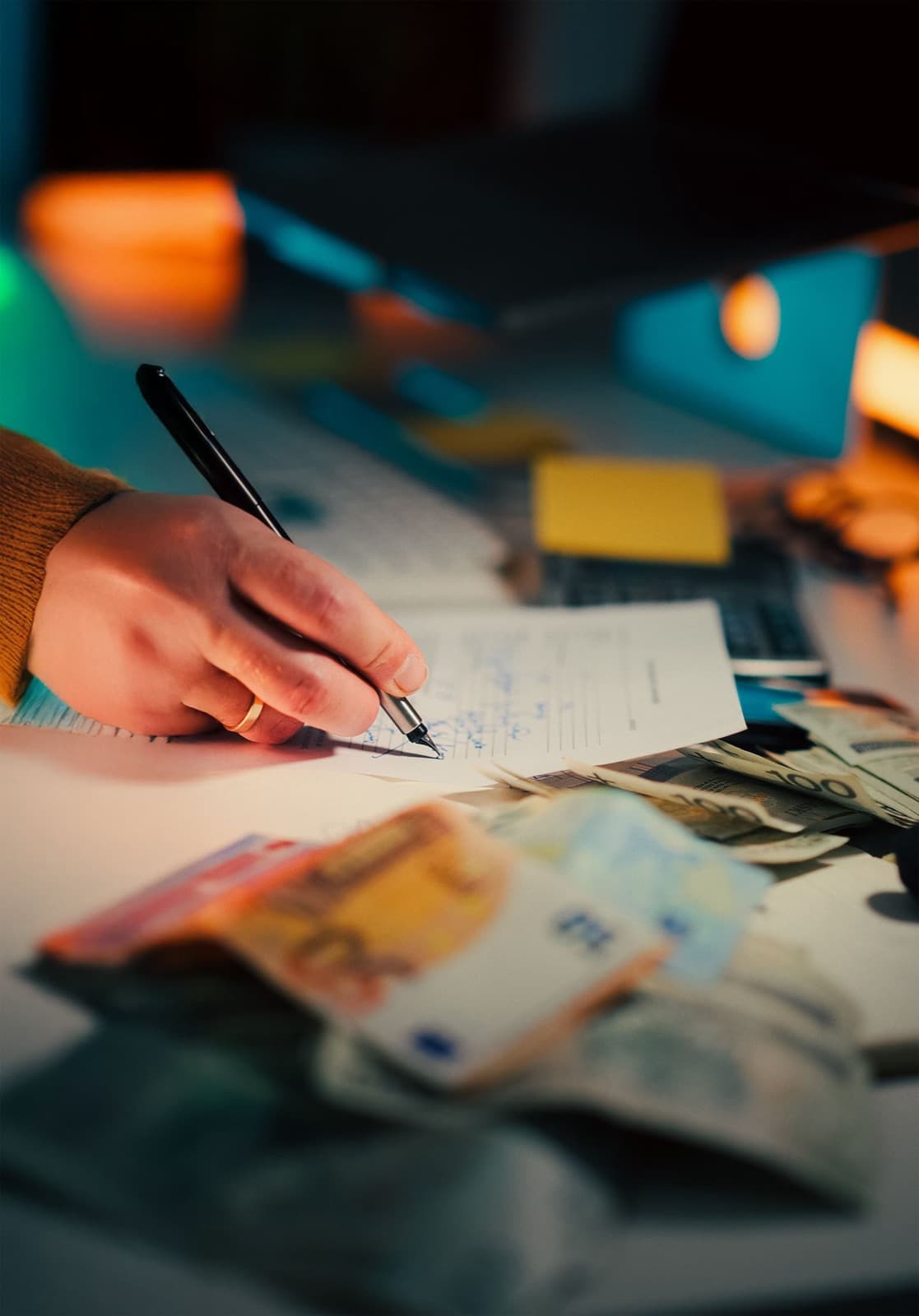 Hand writing on financial documents with a calculator