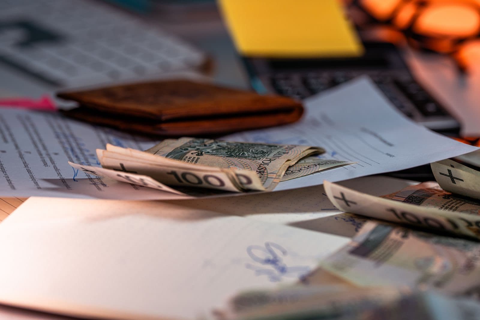 Currency and financial paperwork scattered on a desk