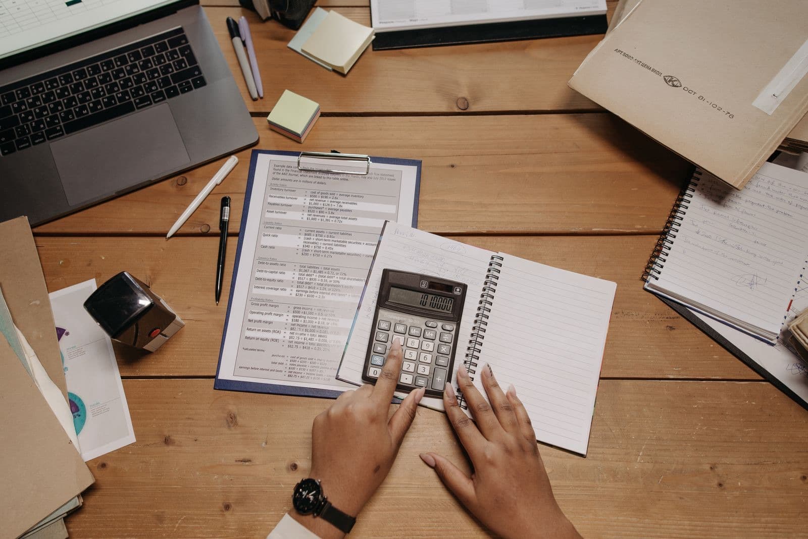 Hands working with a calculator and documents on a desk
