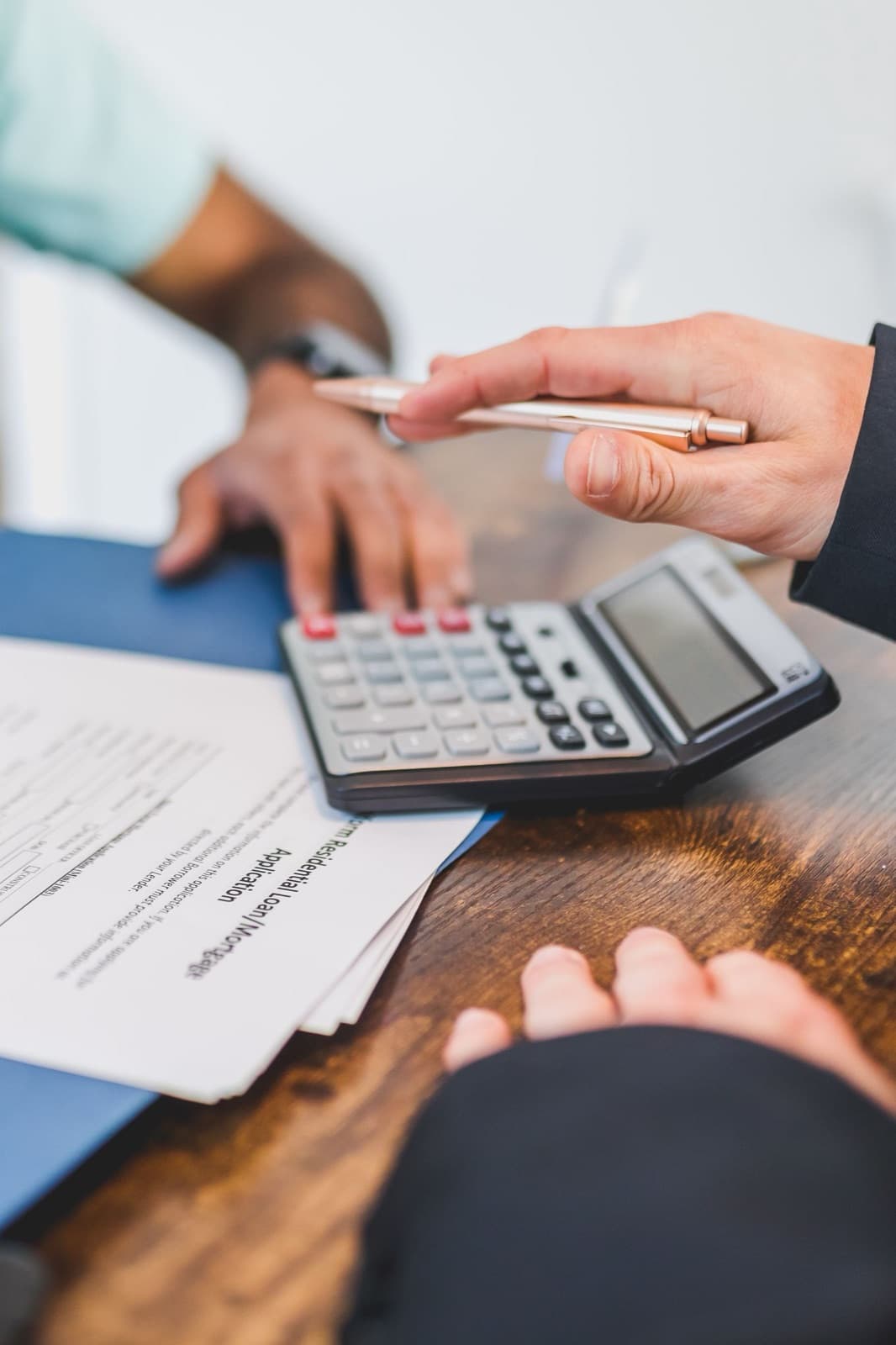 Hands working with a pen and calculator at a desk