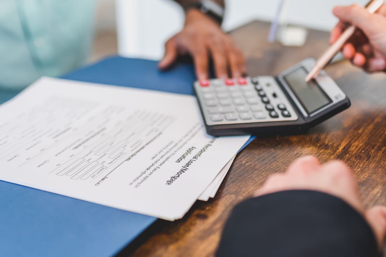Hands using a calculator with real estate documents