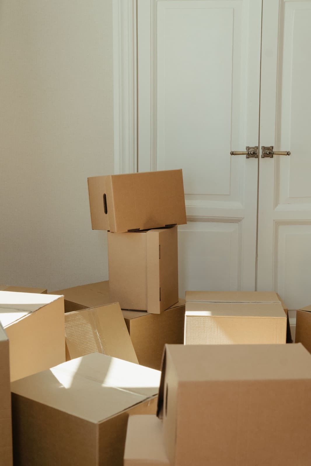 Stack of cardboard boxes by a wooden door on moving day