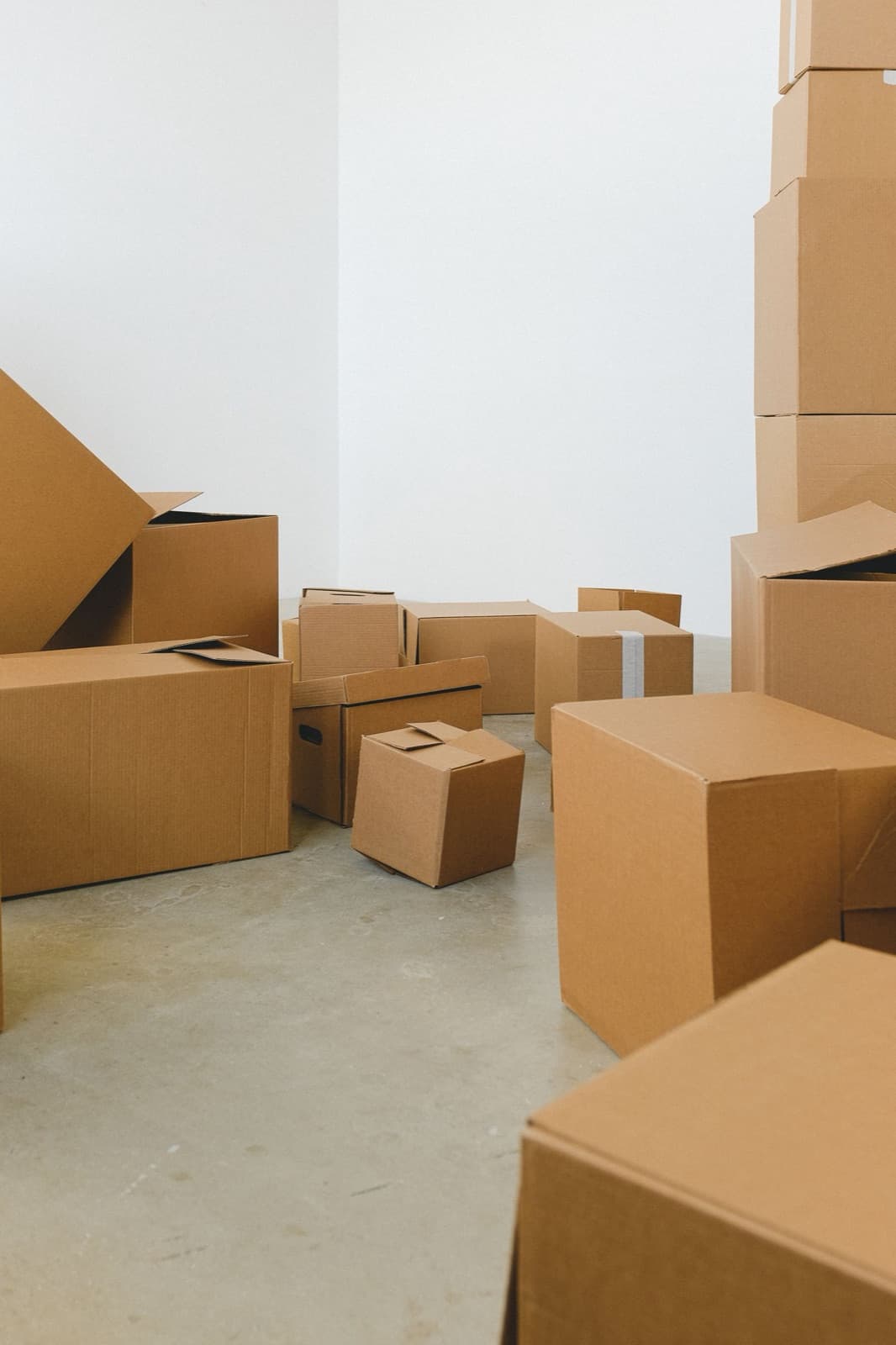 Heaps of cardboard moving boxes on the floor of a house